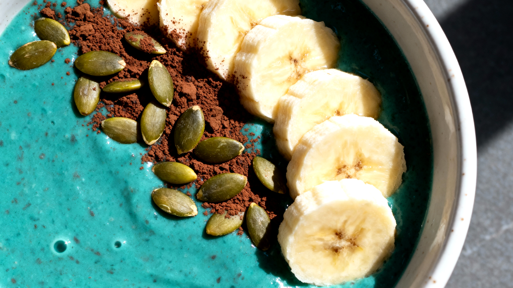 Smoothie bowl con spirulina, banana, semi di zucca e cacao crudo"